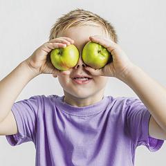 funny kid holding green apples