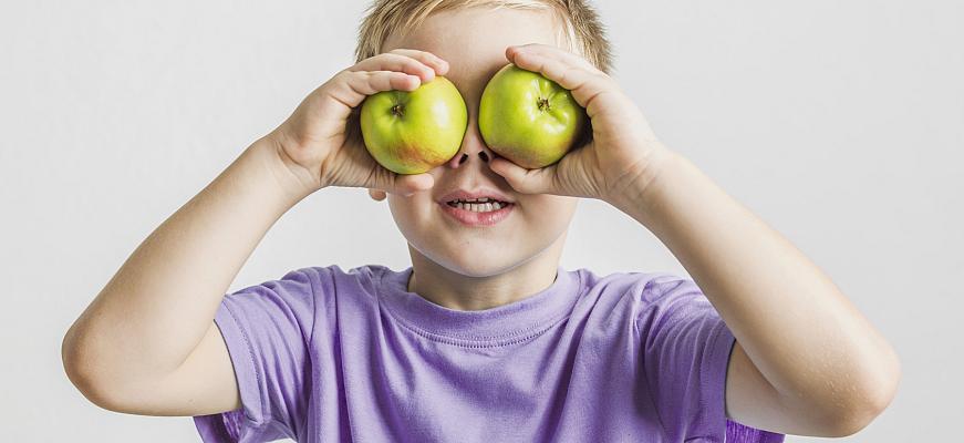 funny kid holding green apples